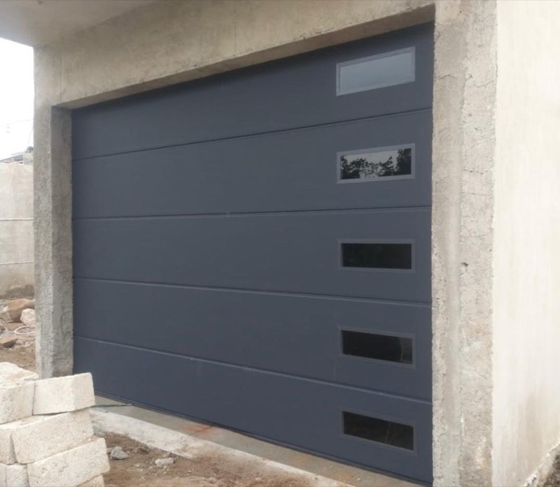 Puerta Seccional Gris Plomo con Columna de Visores Laterales